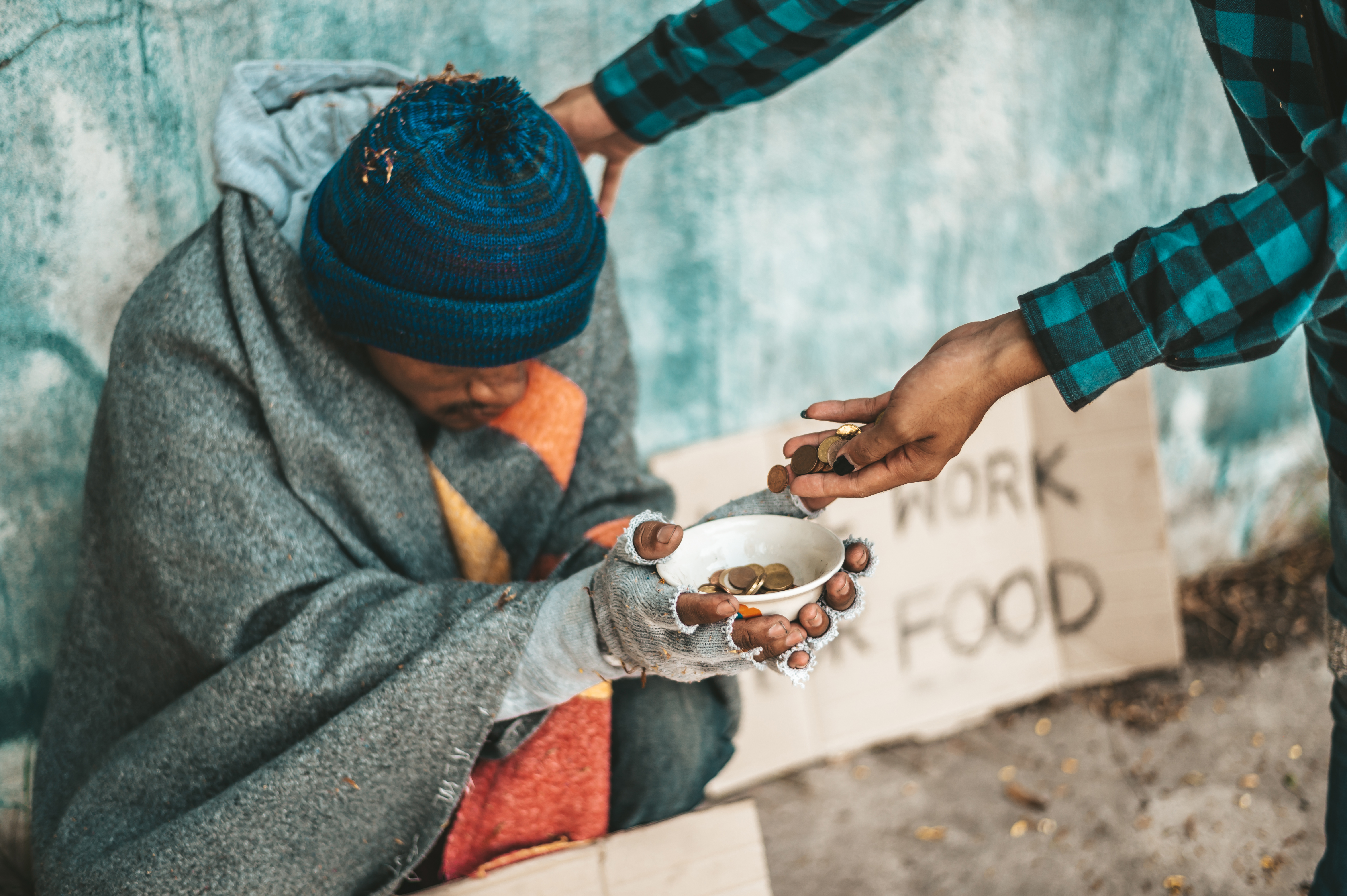 Beggars sitting under the overpass with a credit card and credit card swipe machine.